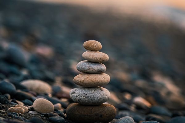 Stack of smooth stones on a beach, symbolizing balance.